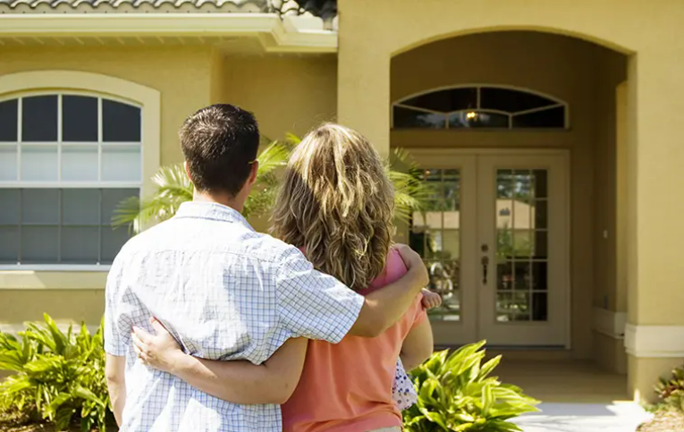 a couple in front of a house